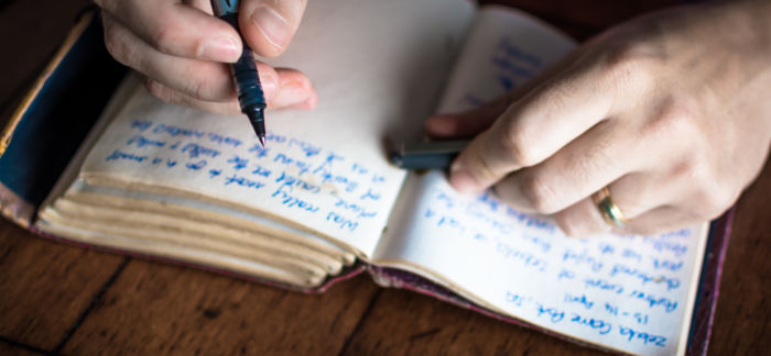 person writing in journal