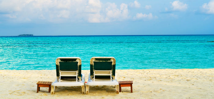 two beach chairs on the ocean sand