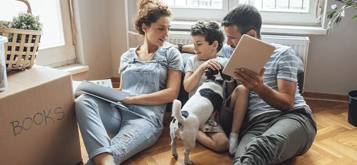 mom and dad with their young child and dog in their new home