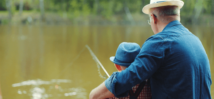 grandfather fishing with his young grandson on a river